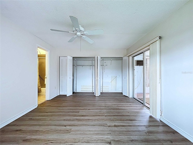 11920 Boynton Ln Unit 11920, New Port Richey, FL 34654 - unfurnished bedroom featuring wood finished floors, a textured ceiling, baseboards, ensuite bath, and access to exterior