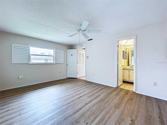 11920 Boynton Ln Unit 11920, New Port Richey, FL 34654 - unfurnished bedroom featuring connected bathroom, baseboards, wood finished floors, and visible vents