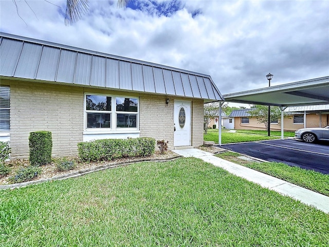 11920 Boynton Ln Unit 11920, New Port Richey, FL 34654 - view of front facade with brick siding, a front yard, and metal roof