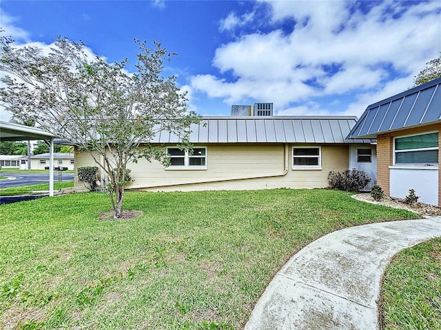11920 Boynton Ln Unit 11920, New Port Richey, FL 34654 - view of home's exterior featuring a lawn and a standing seam roof