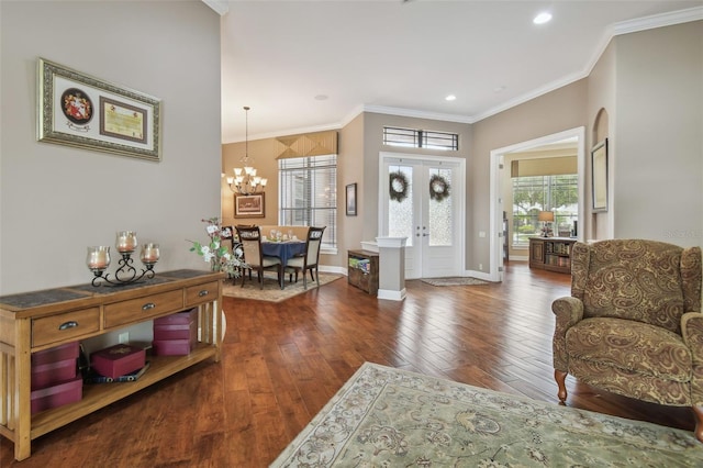 foyer featuring french doors, ornamental molding, a notable chandelier, and dark wood-type flooring