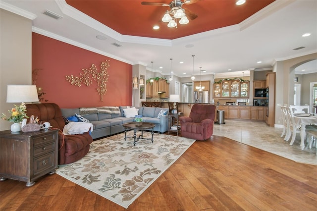 living room featuring ornamental molding, ceiling fan, and wood-type flooring