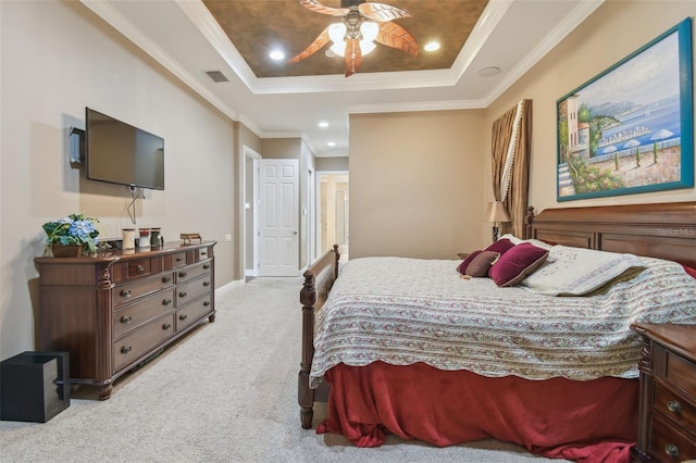 carpeted bedroom featuring ornamental molding, a tray ceiling, and ceiling fan