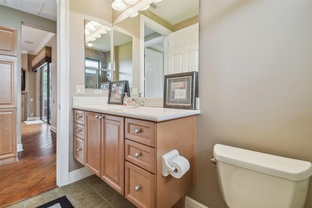 bathroom with vanity, ornamental molding, hardwood / wood-style flooring, and toilet