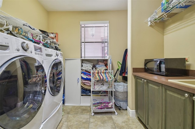 clothes washing area with independent washer and dryer, cabinets, and light tile patterned floors