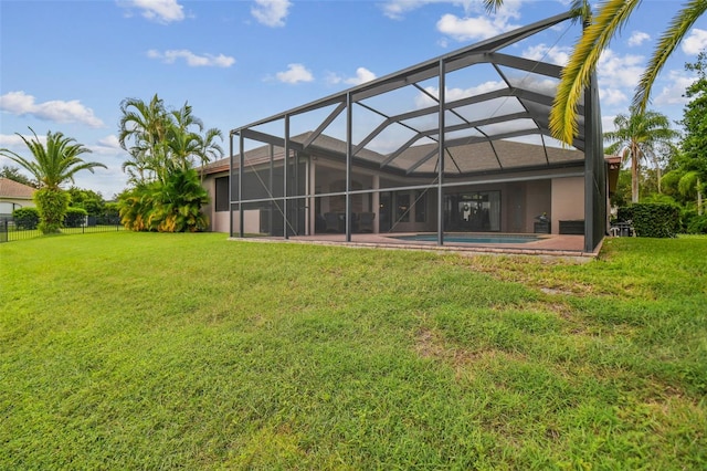 rear view of property with a yard and glass enclosure