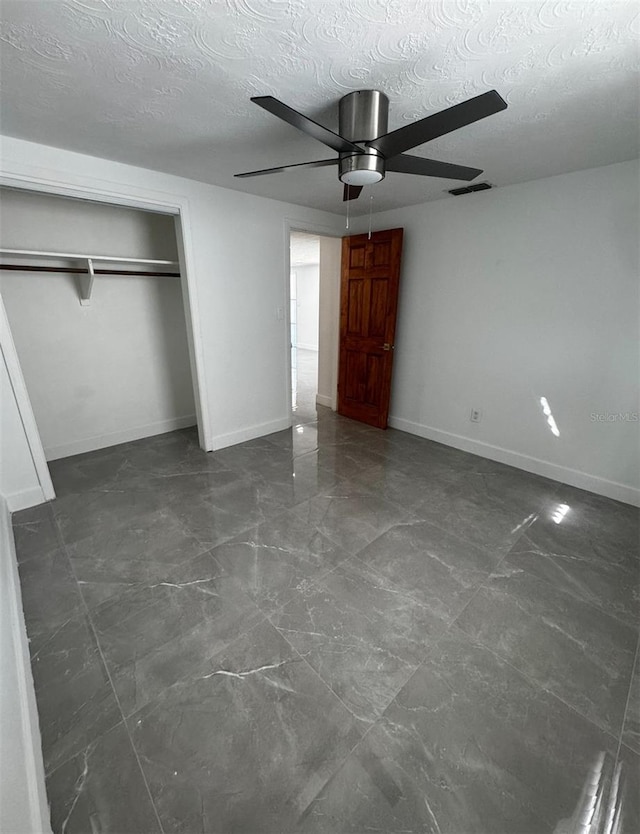 unfurnished bedroom with ceiling fan, a closet, and a textured ceiling