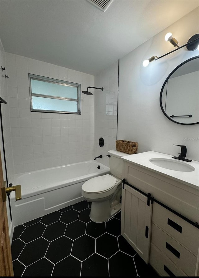 full bathroom featuring tile patterned floors, vanity, toilet, and tiled shower / bath