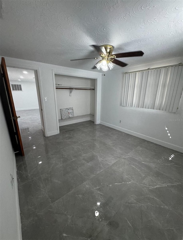 unfurnished bedroom with a textured ceiling, a closet, and ceiling fan