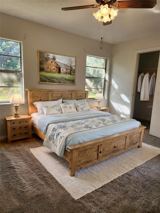 bedroom with a textured ceiling, light colored carpet, ceiling fan, and a closet