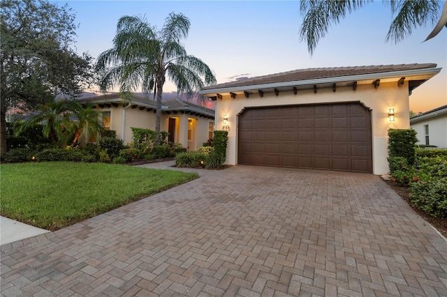 mediterranean / spanish-style house with a yard and a garage