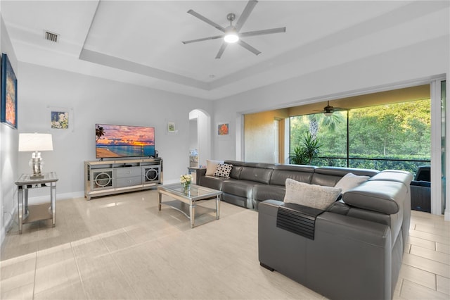 living room featuring light tile patterned floors and a tray ceiling