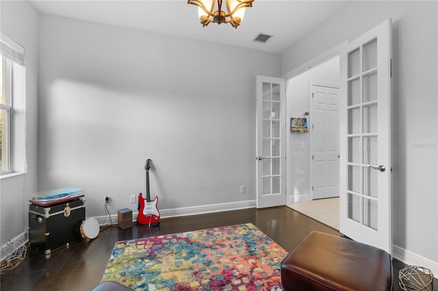 rec room with french doors, dark wood-type flooring, and a notable chandelier