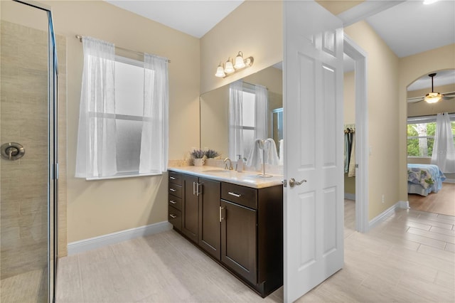 bathroom featuring ceiling fan, a shower with door, and vanity