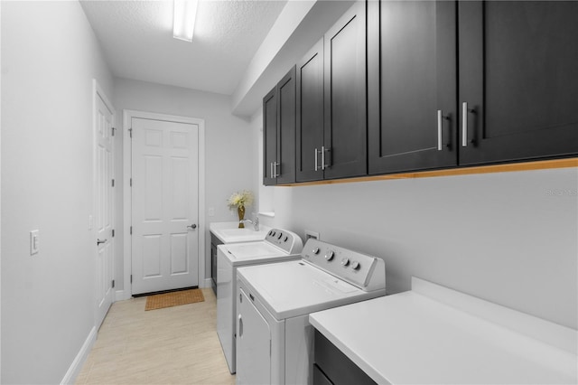 washroom with washer and dryer, sink, cabinets, and a textured ceiling