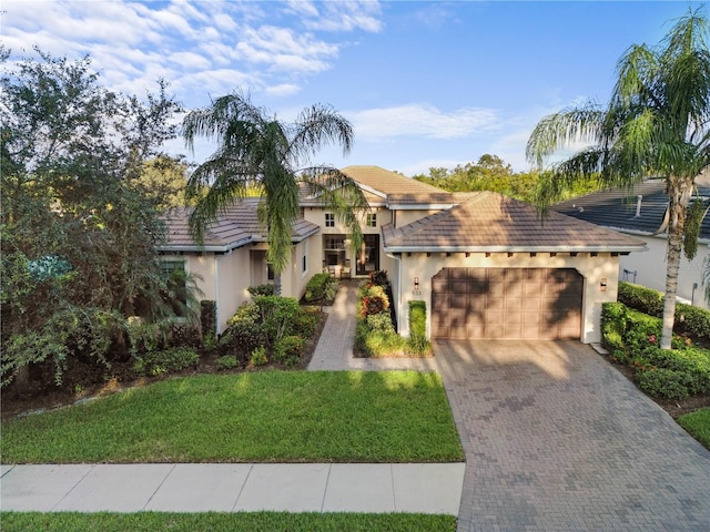 mediterranean / spanish-style home with a front yard and a garage