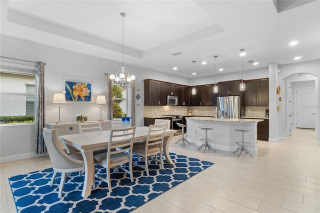 dining room featuring an inviting chandelier and a raised ceiling