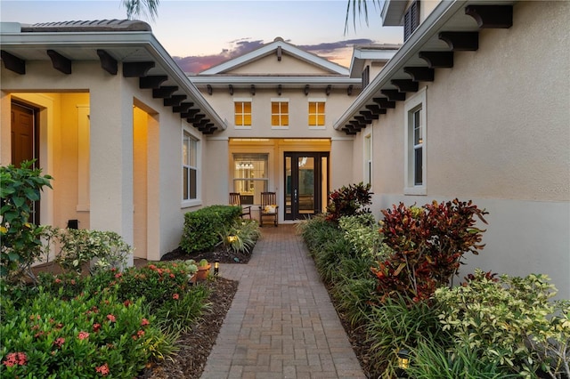 exterior entry at dusk featuring french doors