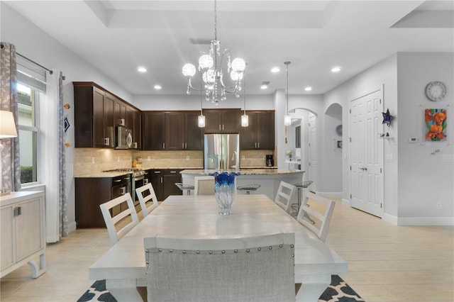 dining area with a notable chandelier, a wealth of natural light, and light hardwood / wood-style flooring