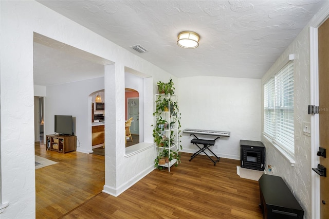 living area with a textured ceiling and hardwood / wood-style floors