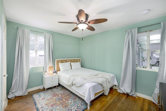 bedroom with ceiling fan and dark wood-type flooring