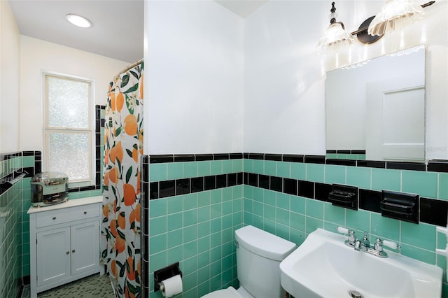 bathroom featuring toilet, tile walls, sink, and curtained shower