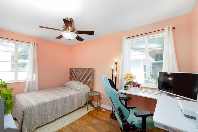 bedroom with ceiling fan, hardwood / wood-style floors, and multiple windows