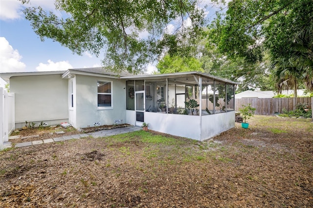 rear view of house featuring a sunroom