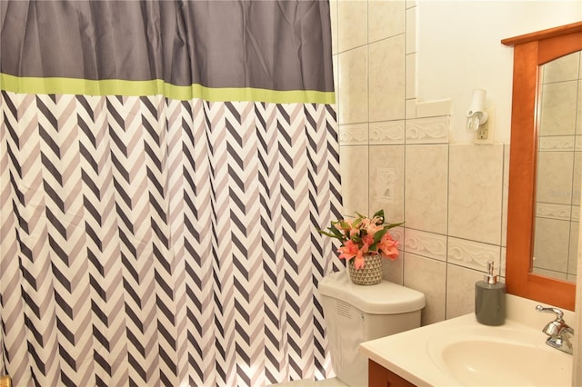 bathroom featuring tile walls, curtained shower, vanity, and toilet