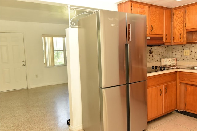 kitchen with stainless steel refrigerator, custom range hood, tasteful backsplash, and gas cooktop