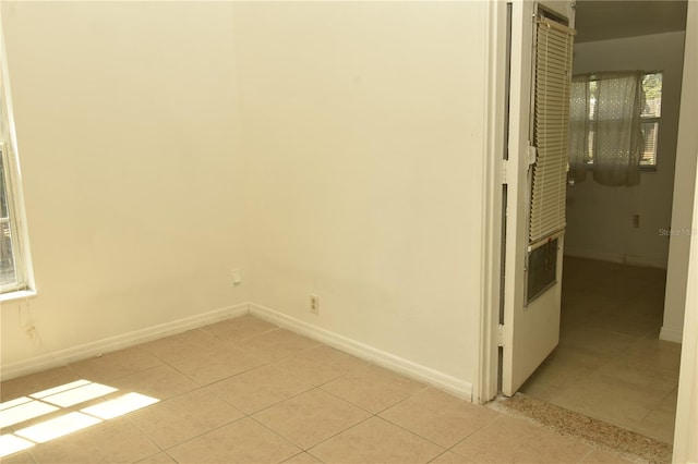 empty room featuring light tile patterned floors and a healthy amount of sunlight