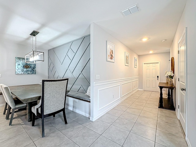 tiled dining area featuring a chandelier