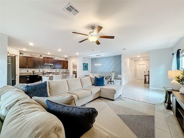 living room with light tile patterned floors and ceiling fan