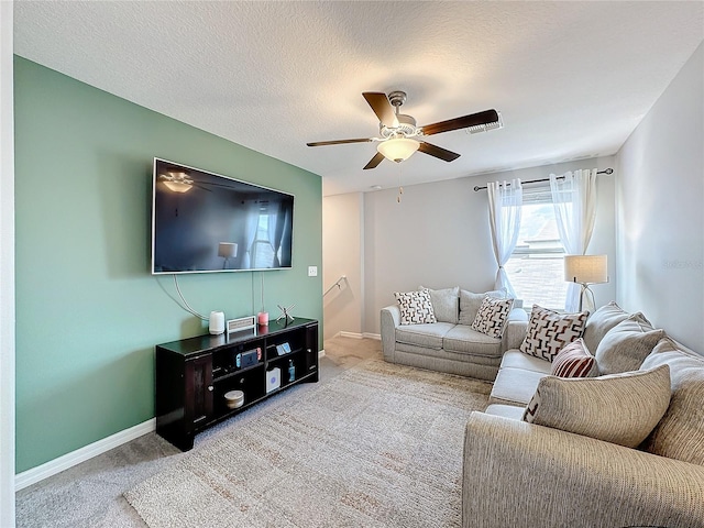 living room featuring a textured ceiling, ceiling fan, and carpet floors