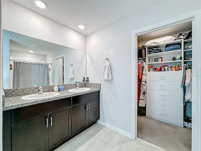 bathroom featuring vanity, a textured ceiling, and tile patterned flooring