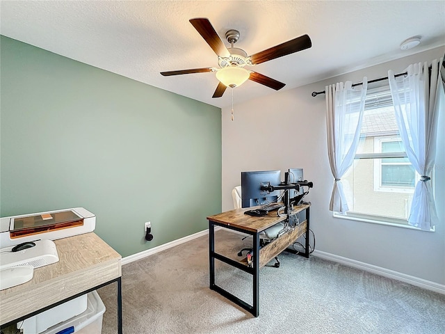 carpeted office with a textured ceiling and ceiling fan