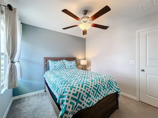 carpeted bedroom featuring a textured ceiling and ceiling fan