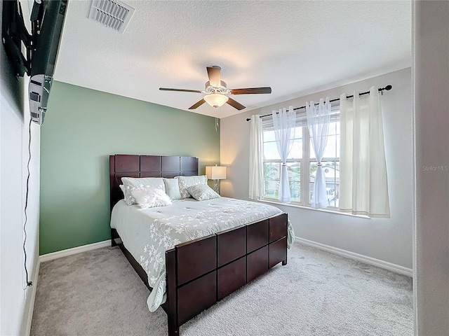 carpeted bedroom featuring a textured ceiling and ceiling fan