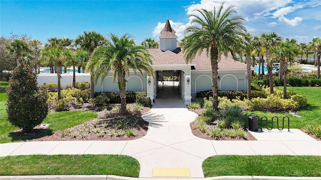 mediterranean / spanish-style home with a garage and a front lawn