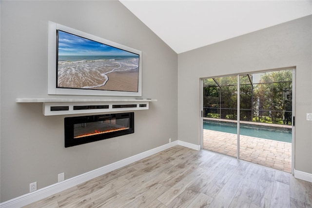 interior space featuring light hardwood / wood-style floors and vaulted ceiling