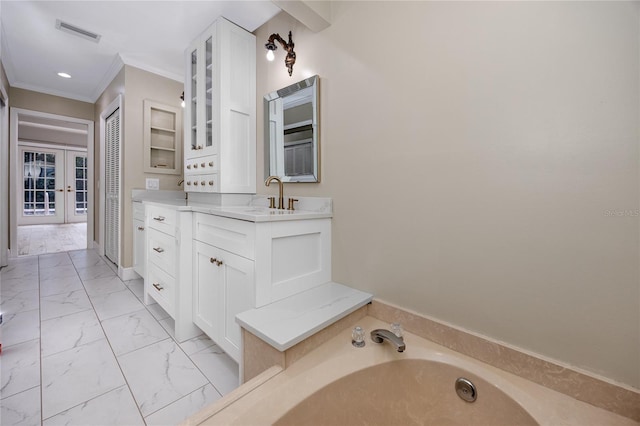 bathroom featuring ornamental molding, vanity, and a tub