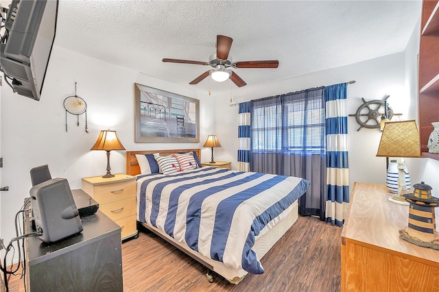 bedroom featuring ceiling fan, a textured ceiling, and dark hardwood / wood-style flooring