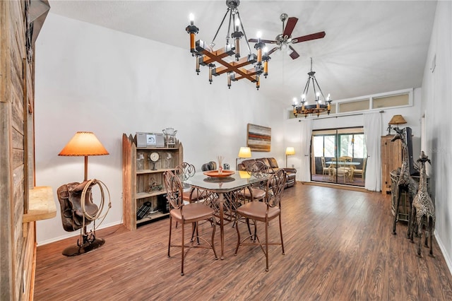 dining space featuring ceiling fan with notable chandelier, vaulted ceiling, and hardwood / wood-style flooring