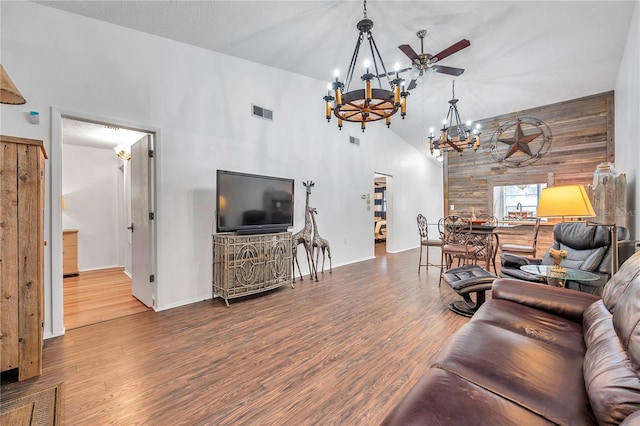 living room featuring ceiling fan with notable chandelier, hardwood / wood-style floors, and high vaulted ceiling