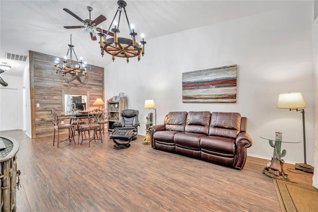 living room featuring ceiling fan with notable chandelier and hardwood / wood-style flooring