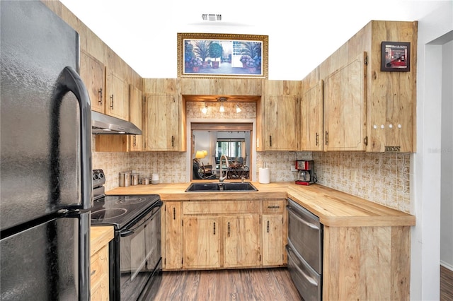 kitchen with appliances with stainless steel finishes, dark hardwood / wood-style floors, sink, and wood counters