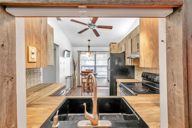 kitchen featuring sink, vaulted ceiling, decorative backsplash, black appliances, and ceiling fan