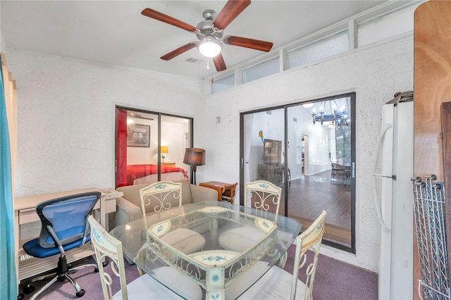 carpeted dining room with ceiling fan