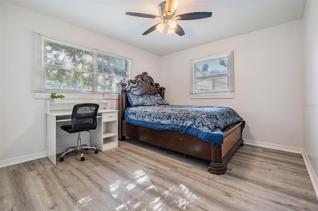 bedroom featuring ceiling fan, light wood-type flooring, and multiple windows