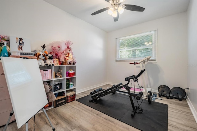 workout area featuring light wood-type flooring and ceiling fan